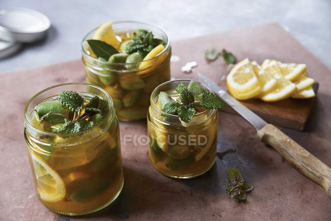 Pickled green almonds with lemons — Stock Photo