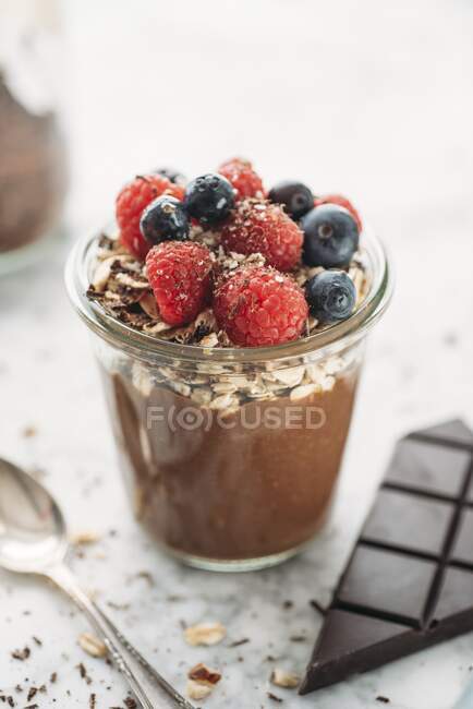 Kokos-Schokoladen-Joghurt mit Haferflocken, Nüssen und Beeren (vegan)) — Stockfoto