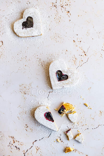 Heart shaped cookies with raspberry jam (and a broken heart) — Stock Photo