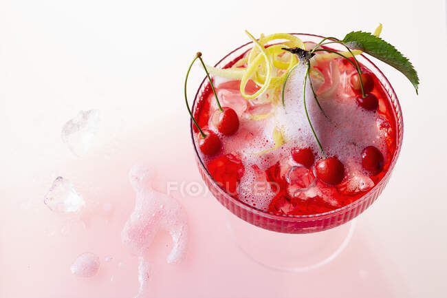 A cherry cocktail with gin, ginger ale and mini wild cherries — Stock Photo