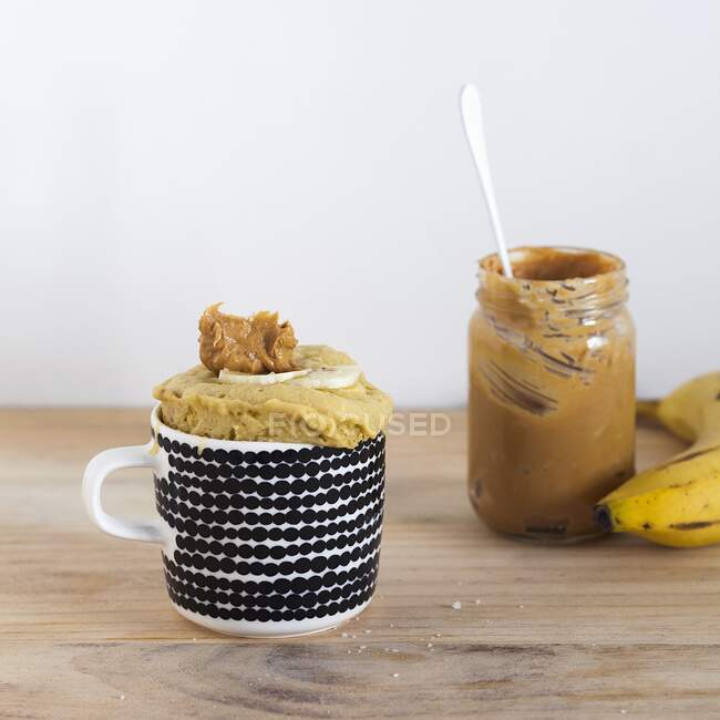 Banana bread mug cake with a jar of peanut butter — Stock Photo