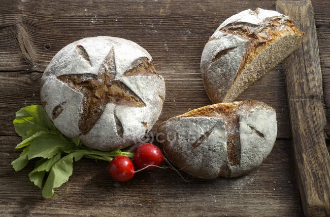Dos panes de pan de castaño sobre una superficie de madera - foto de stock