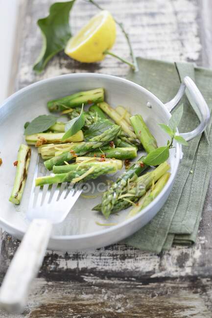 Fried green asparagus with lemon — Stock Photo