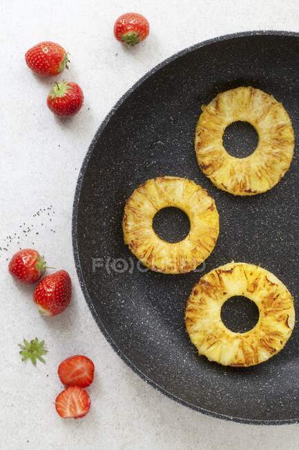Кольца ананаса в сковороде — стоковое фото