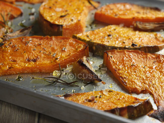 Pumpkins wedges roasted with garlic and rosemary — Stock Photo