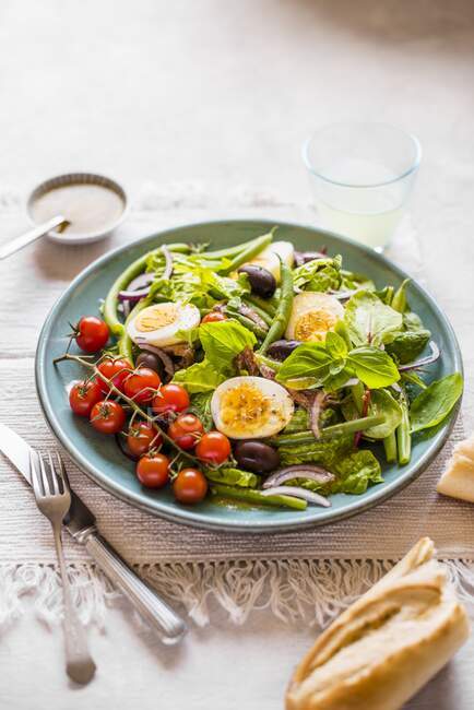 Гарний салат з квасолею. Яйця, анчоуси, оливки та помідори — стокове фото
