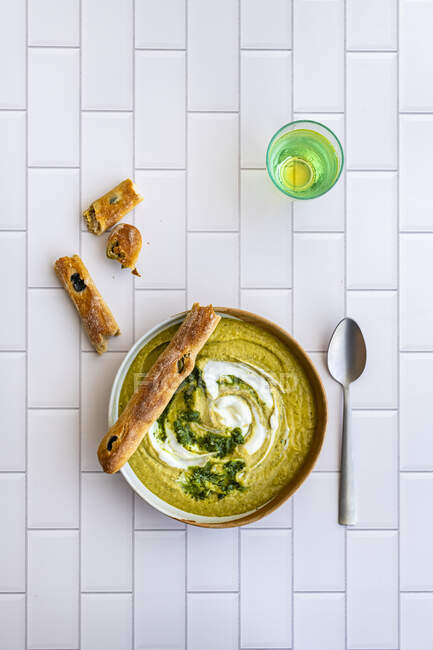 Broccoli soup with olive bread sticks — Stock Photo
