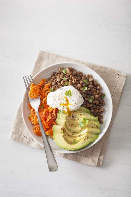 Spiralized carrot and avocado bowl with poached egg and lentils — Stock Photo