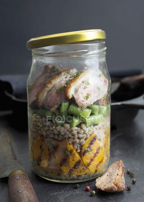 Roasted duck breast with buckwheat, grilled sweet potatoes and green beans in a glass jar — Stock Photo