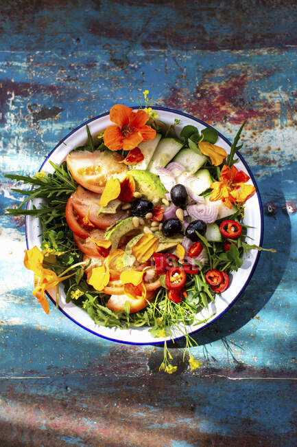 Summer salad with tomatoes, cucumber, chili, olives and edible flowers — Stock Photo