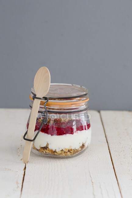Banana granola in a jar with yoghurt and raspberry puree — Stock Photo