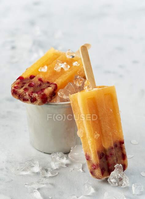 Манго гранат мороженое на ручке с дробленым льдом — стоковое фото