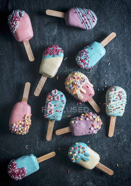 Pastel aparece en forma de paletas de hielo con glaseado de colores brillantes (visto desde arriba) - foto de stock