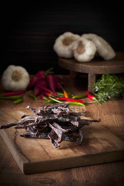 Beef steak with vegetables and spices on wooden table — Stock Photo