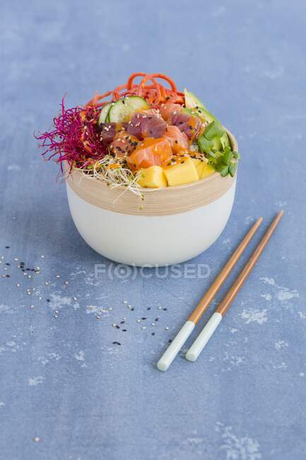 Poke bowl avec thon et saumon et baguettes sur la table — Photo de stock
