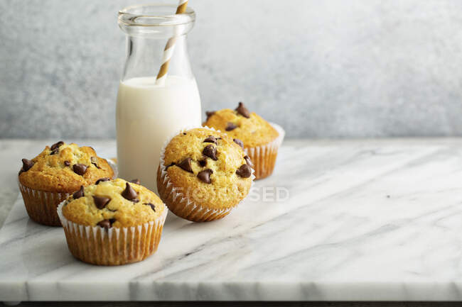Chocolate Chip Muffins mit einer Flasche Milch — Stockfoto