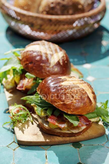 Lye buns with scrambled eggs and bacon — Stock Photo