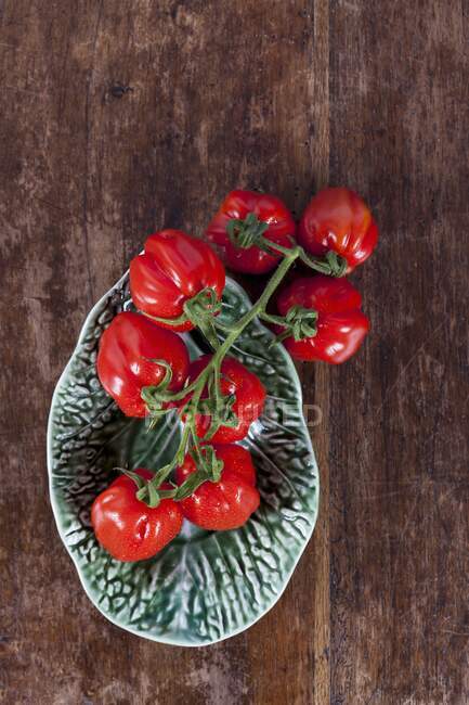 Маленькі сливові помідори в керамічній мисці — стокове фото