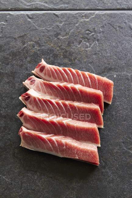 Salted tuna steaks on slate background — Stock Photo