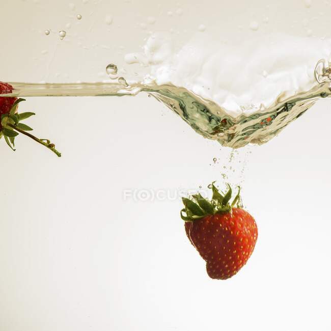 Erdbeere fällt ins Wasser — Stockfoto