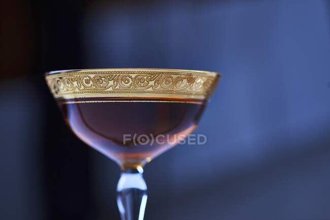 Манхэттенский коктейль в элегантном стакане с золотой оправе — стоковое фото
