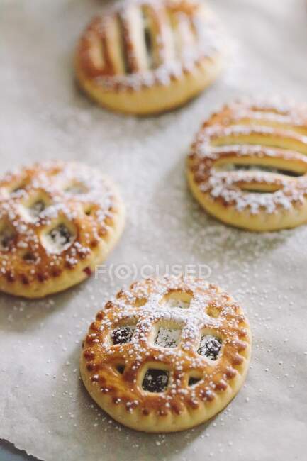 Biscotti con marmellata e zucchero a velo su pergamena — Foto stock