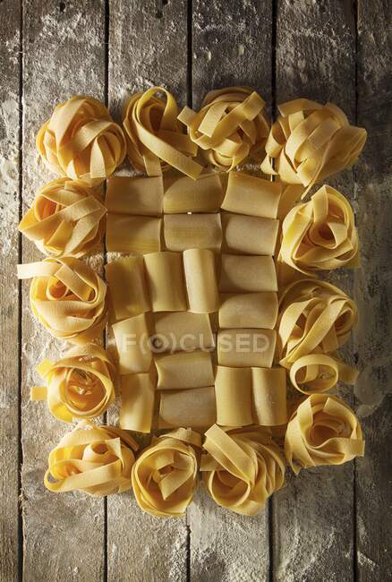 Italian pastas with flour on a wooden table — Stock Photo