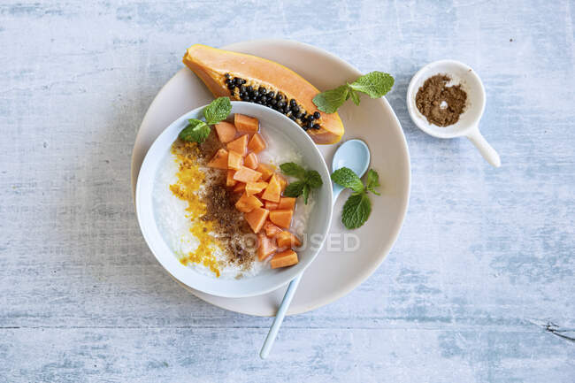 Congee (arroz con leche) con papaya - foto de stock