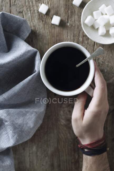Eine Hand hält eine Tasse Kaffee (Ansicht von oben)) — Stockfoto