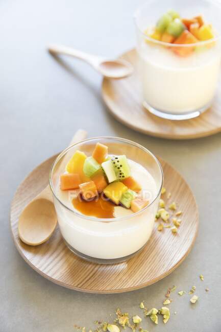 Panna cotta with exotic fruits, honey and pistachios — Stock Photo