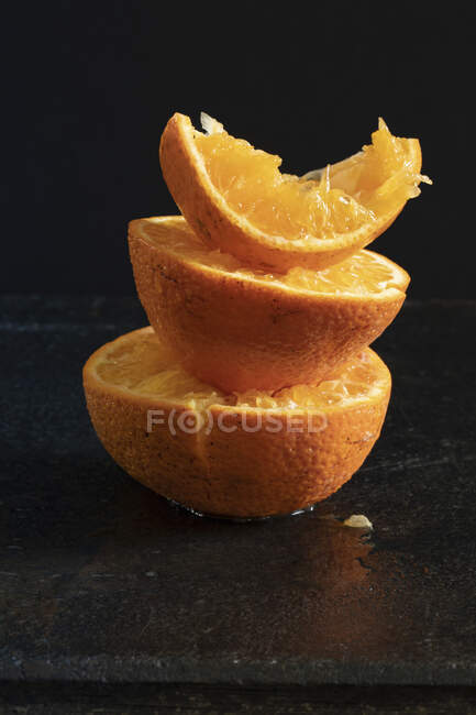 Stack of juiced oranges on dark background — Stock Photo