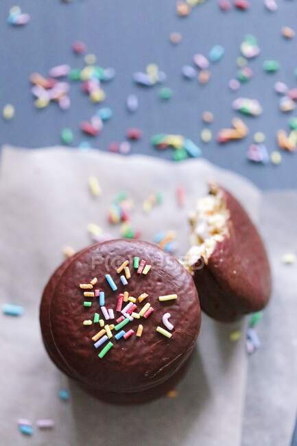 Macaroons em esmalte de chocolate com polvilhado de doces — Fotografia de Stock