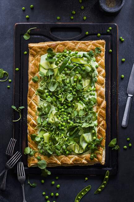 A puff pastry tart with cream cheese, peas, courgette and watercress salad — Stock Photo