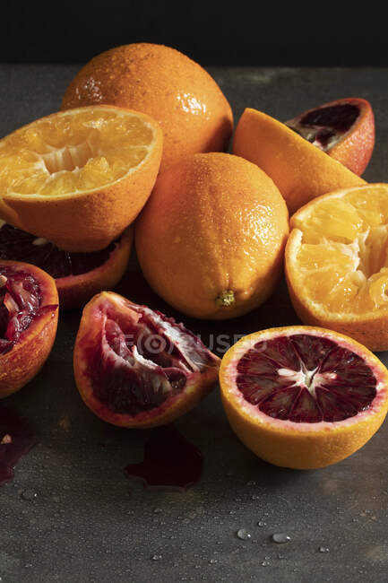 Oranges and blood oranges, partially juiced — Stock Photo