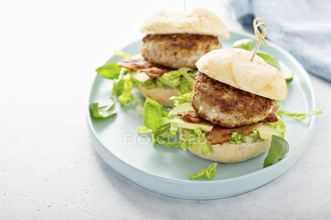 Turkey burgers with avocado, lettuce and bacon — Stock Photo