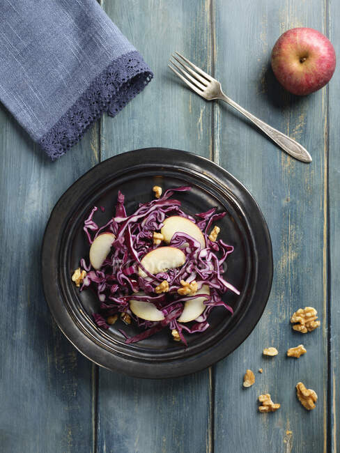 Red cabbage salad with apples slices and nuts — Stock Photo