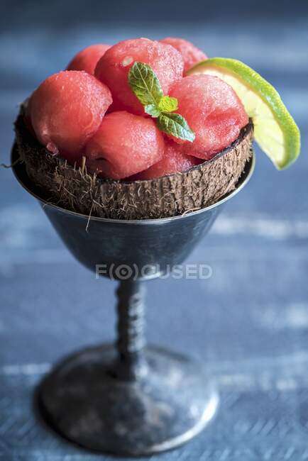 Арбузные шарики в кокосовой скорлупе и блюде из мороженого — стоковое фото