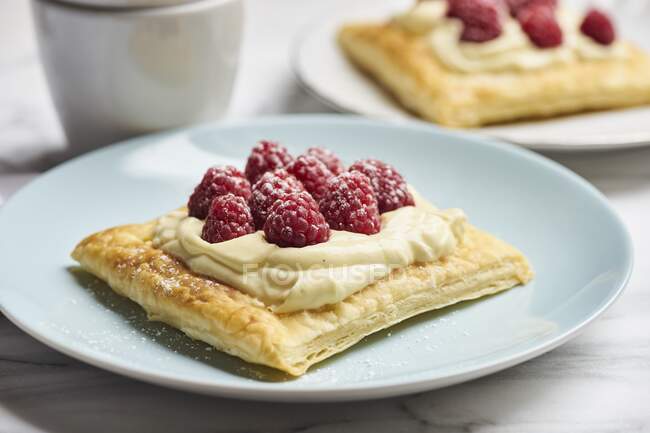 Puff pastry slices with vanilla cream and raspberries — Stock Photo