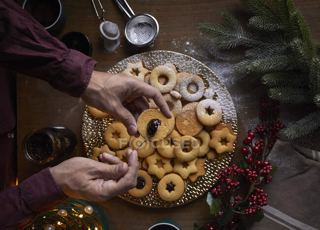 Spreading jam on freshly baked Linzer cookies — Stock Photo