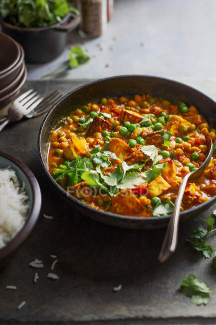 Curry vegetariano com grão de bico, ervilhas, tomates, coentro e queijo paneer indiano — Fotografia de Stock