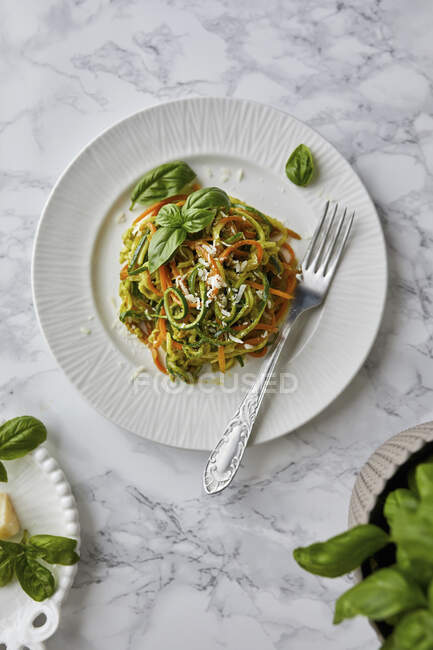 Raw zucchini and carrot noodles with basil pesto sauce — Stock Photo