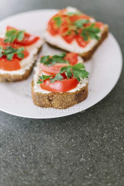 Bruschetta topped with cottage cheese and tomatoes — Stock Photo