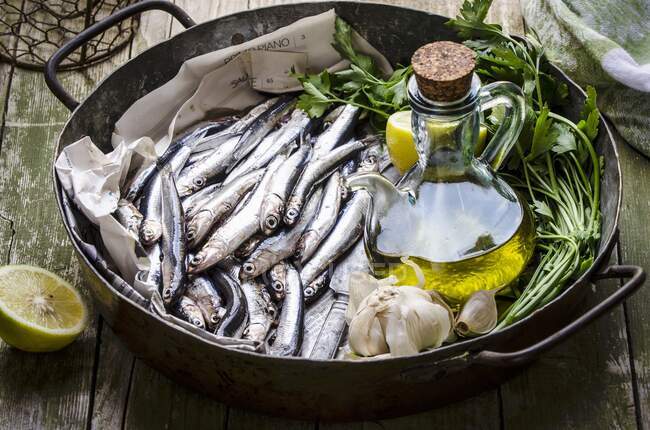 Frische Sardellen, Olivenöl, Knoblauch, Zitrone und Petersilie — Stockfoto