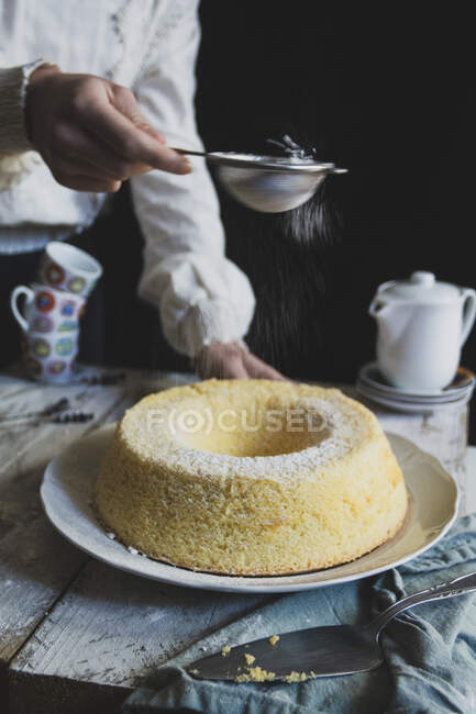 Spreading sugar on chiffon cake — Stock Photo
