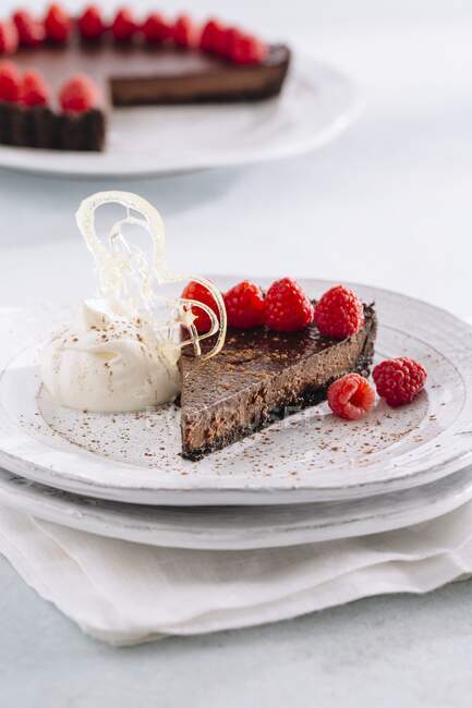Tarta de chocolate con frambuesas frescas y crema batida - foto de stock