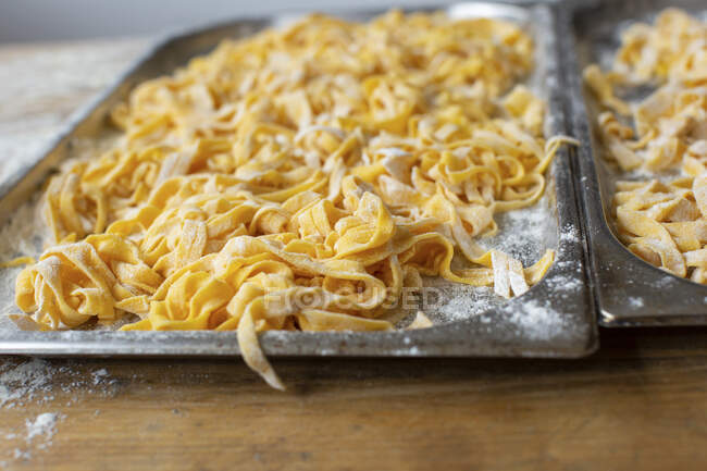 Fresh pasta on oven trays — Stock Photo