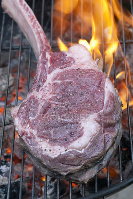 Tomahawk steak on charcoal grill — Stock Photo