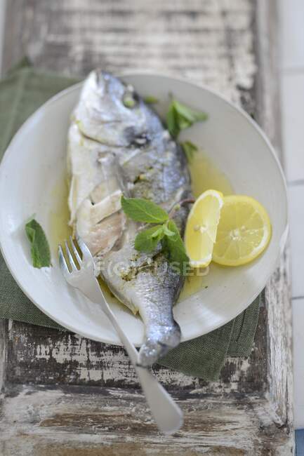 Poached dorade with lemon and mint — Stock Photo