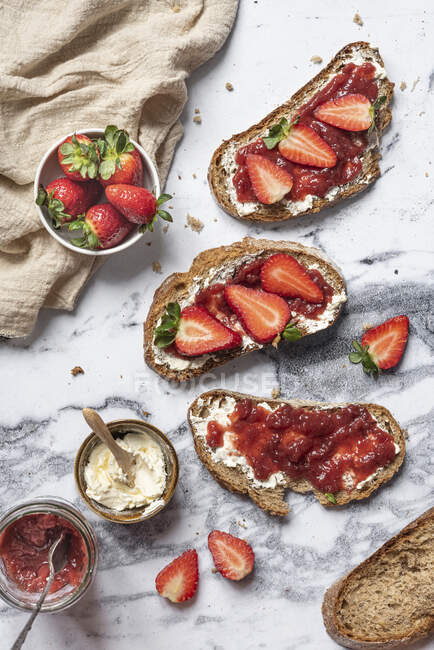 Buttermarmelade Toasts mit frischen Erdbeeren auf Marmoroberfläche — Stockfoto