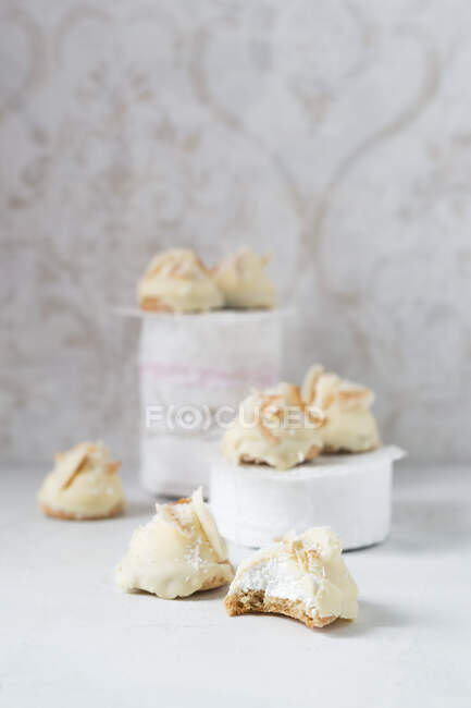 Homemade foam kisses with white chocolate and coconut shavings on a biscuit base — Stock Photo